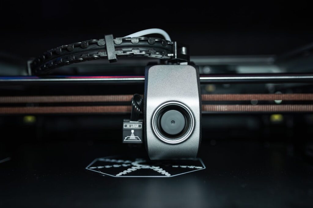 pexels-photo-20877039 Detailed close-up of a 3D printer extrusion head in focus, showcasing modern technology.